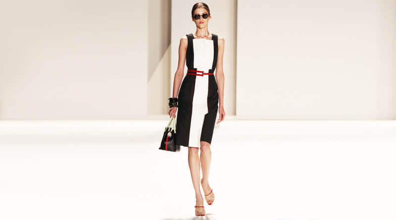Imagen de mujer con figura estilizada, usando un vestido blanco con negro.