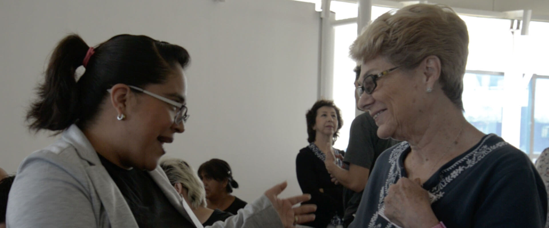 Profesoras platicando en el curso al adulto mayor.