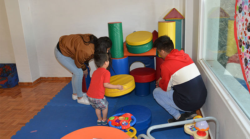 Niño y adultos jugando.