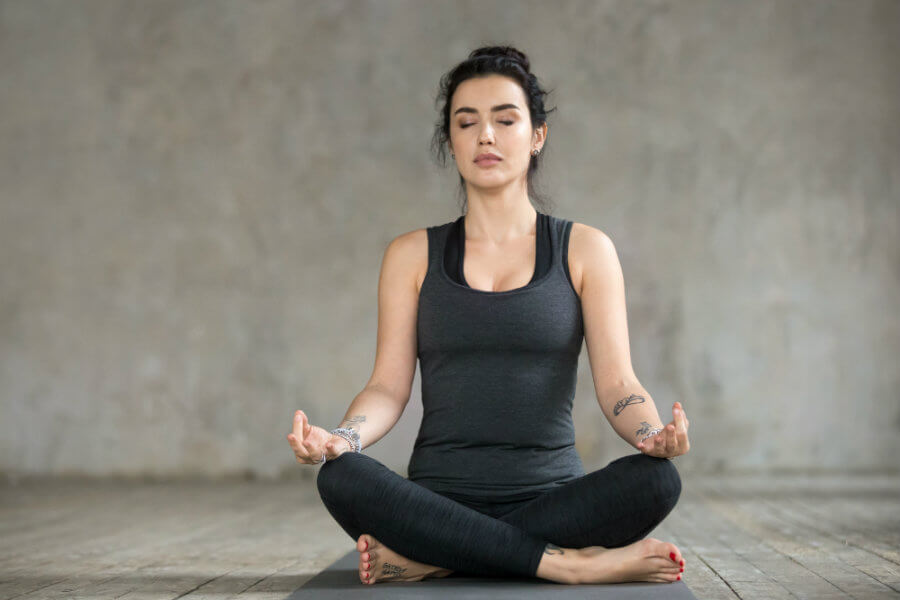 Mujer haciendo yoga postura de loto o padmasana