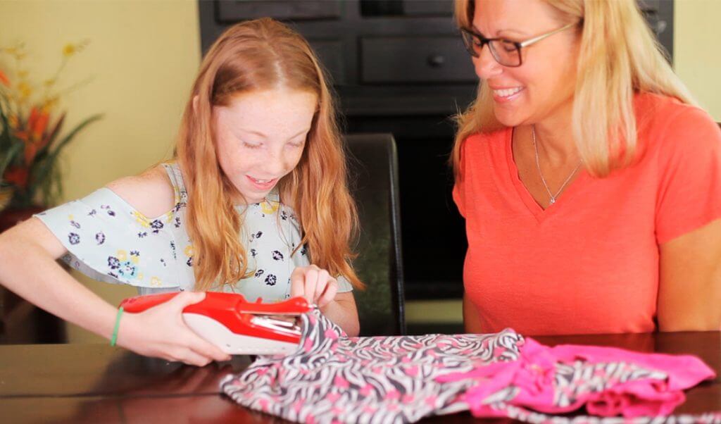 Madre e hija cosen con máquina portátil